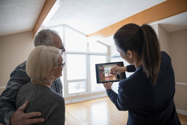 Une agent immobilier qui présente une maison à un couple de seniors