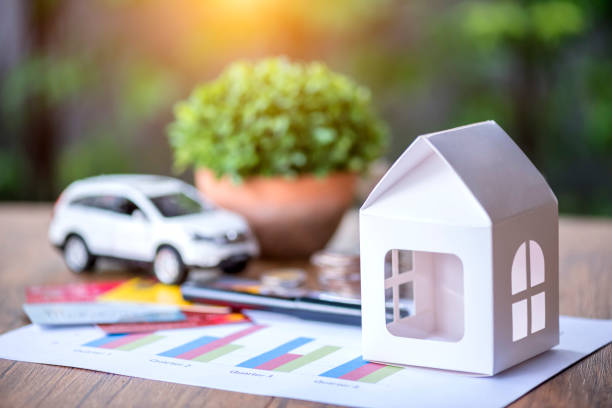 Maison en papier et petite voiture sur une table en bois